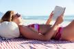 žen ačita knjigu na plaži