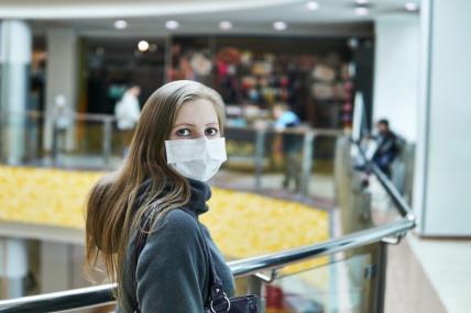 žena s maskom za lice zbog koronavirusa u shopping centru