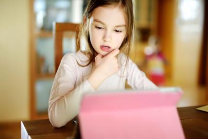 djevojčica na online nastavi kod kuće pokušava se motivirati na učenje