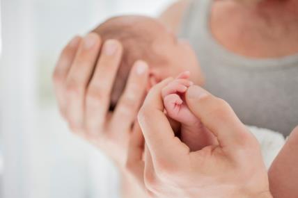 tata drži u rukama tek rođenu bebu