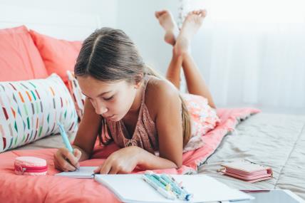 djevojčica uči i piše domaću zadaću