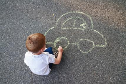 dijete crta auto na asfaltu