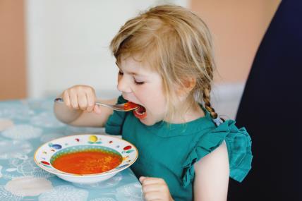 djevojčica jede juhu od rajčice