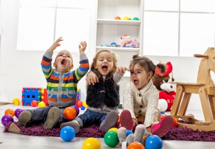 troje djece se igra u sobi lopticama