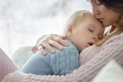 Mama u naručju drži dijete s visokom temperaturom