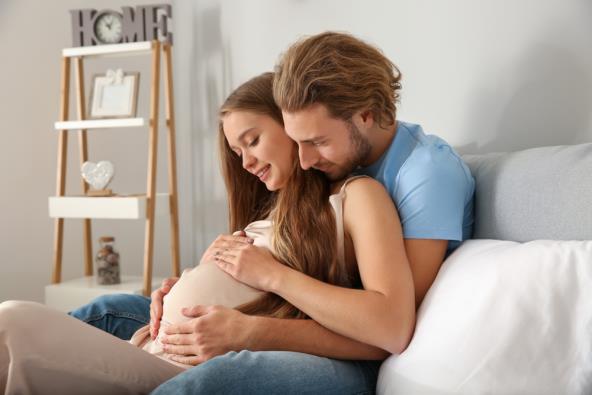 trudnica i partner sjede na krevetu
